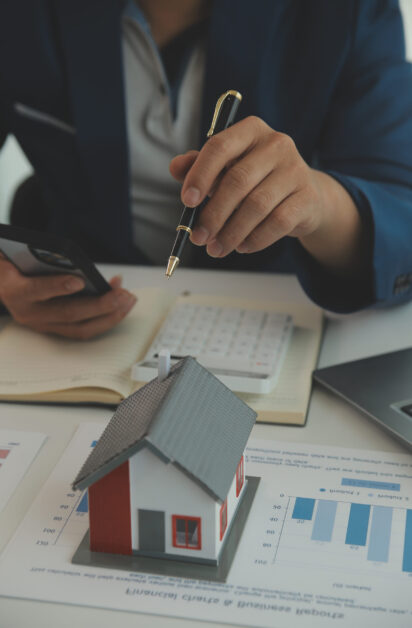 Businessmen holding pens, signing home titles with insurance, ca Businessmen holding pens, signing home titles with insurance, care about real estate services and the idea of real estate agents offering interest in installments to their customers.